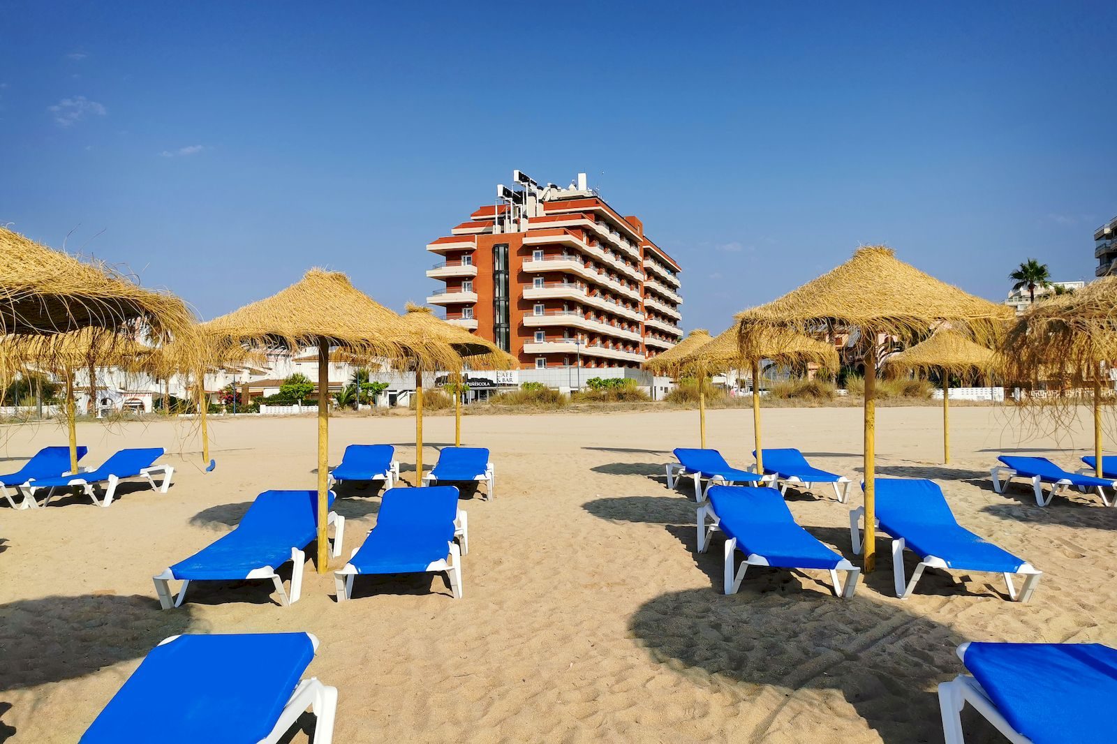 Beach club hotel Acualandia Peñíscola con hamacas y sombrillas en la playa