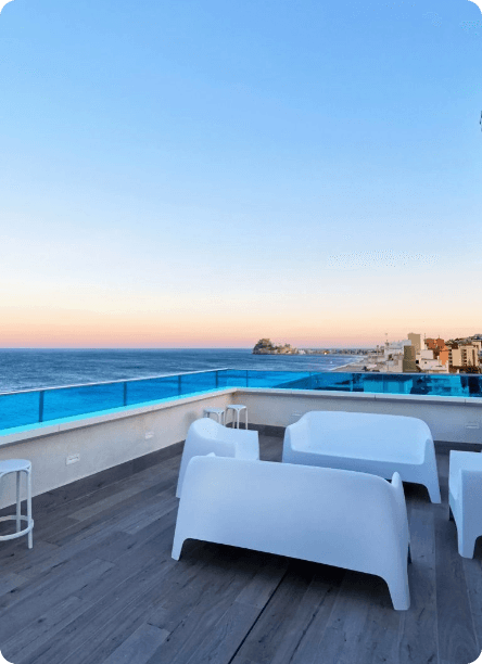Terraza rooftop de Hoteles Mediterráneo con sofás blancos al atardecer y vistas al Castillo de Peñíscola